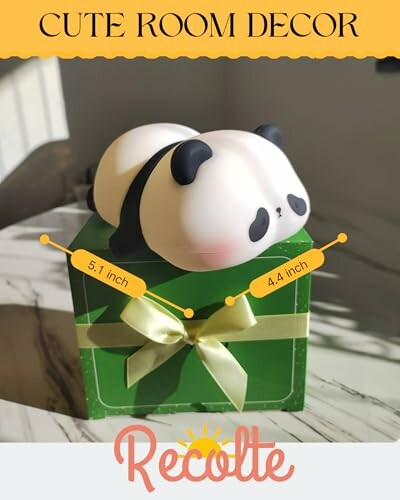 Cute panda-shaped room decor on a green gift box.