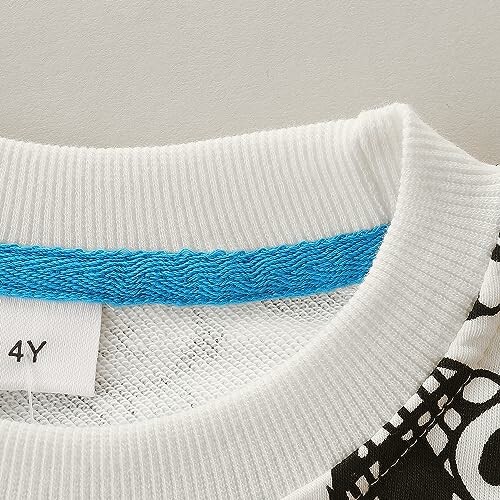 Close-up of a children's shirt collar with a blue stripe and size tag.