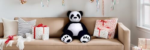 Stuffed panda on a couch surrounded by gift boxes.