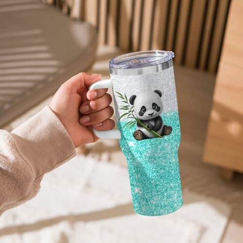 Hand holding a tumbler with a cute panda design.