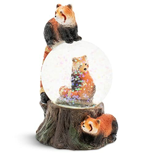 Red panda snow globe with figurines on a tree base.